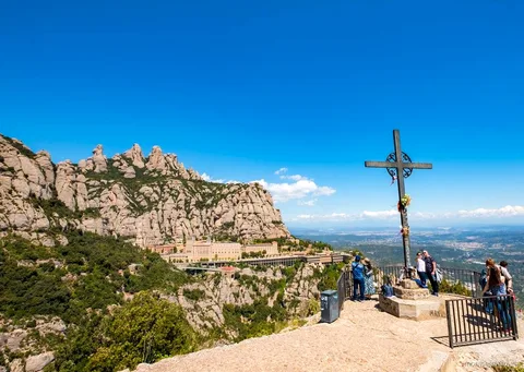 Hikers on a marked trail through Montserrat National Park with rock peaks behind