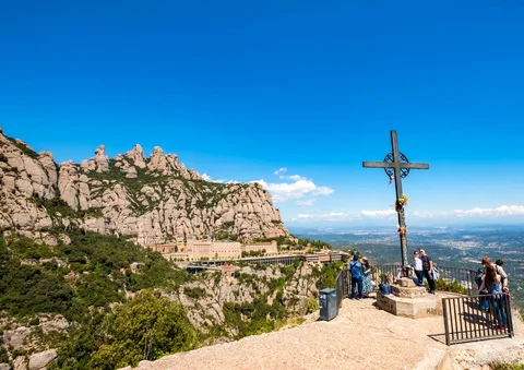 Senderistas en un sendero señalizado del Parque Natural de Montserrat con picos rocosos detrás